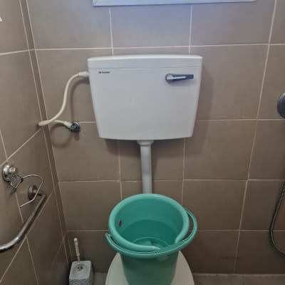 דלי ירוק על אסלה בחדר שירותים