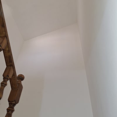 קיר צבוע בלבן עם מעקה עץ בצד