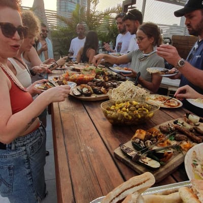 אנשים נהנים מאוכל מגוון באירוע קייטרינג בחוץ