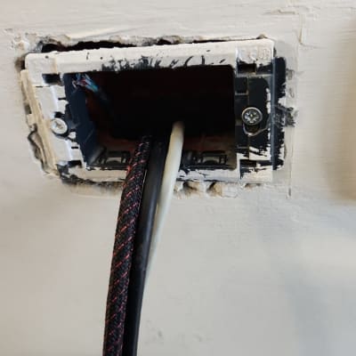 חוטי חשמל יוצאים מקופסת חיבורים בקיר