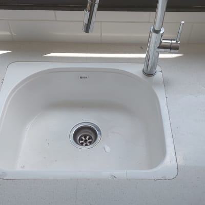 כיור מותקן בשיש לבן עם כלים לידו