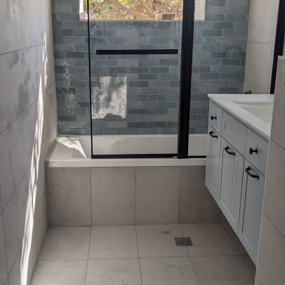 חדר אמבטיה עם אריחים חדשים ודלת זכוכית