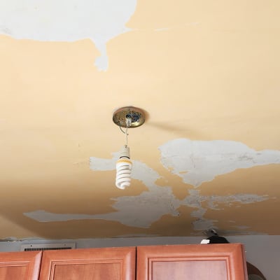 תקרה מתקלפת עם מנורה תלויה