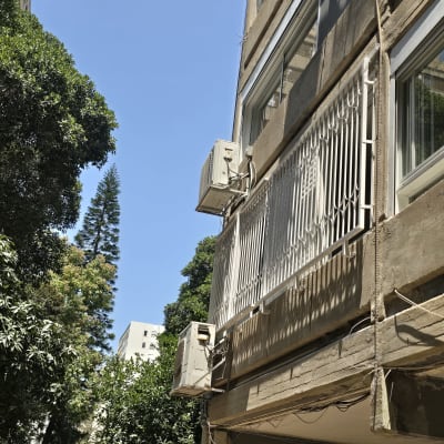 מרפסת עם סורגים ומזגן על קיר חיצוני