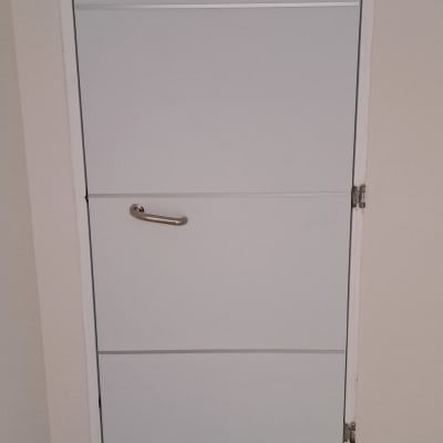 דלת לבנה עם ידית מתכת וחיבורים בצד