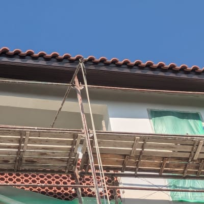 גג רעפים אדומים עם פיגומים לבנייה