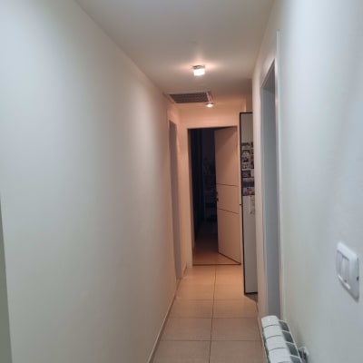 מסדרון עם קירות צבועים בלבן ותאורה עליונה