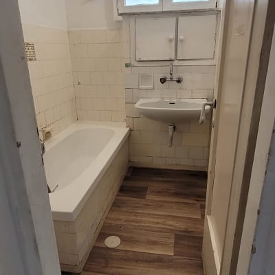 רצפת פרקט עץ בחדר אמבטיה עם אמבטיה וכיור