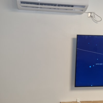 מזגן תלוי על קיר ליד מסך טלוויזיה