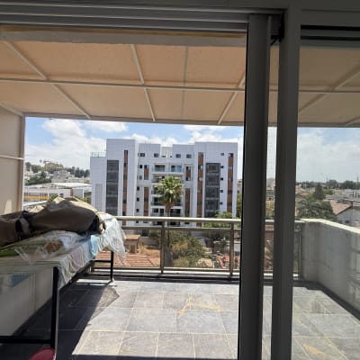 מרפסת עם נוף לבניין מגורים ועצים