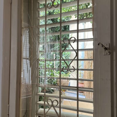 זכוכית חלון שבורה עם סורגים מתכתיים