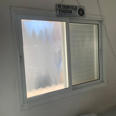 חלון זכוכית עם שלט בלומפילד סטדיום תלוי מעליו