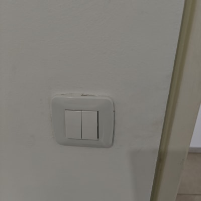 מתג חשמל כפול על קיר לבן