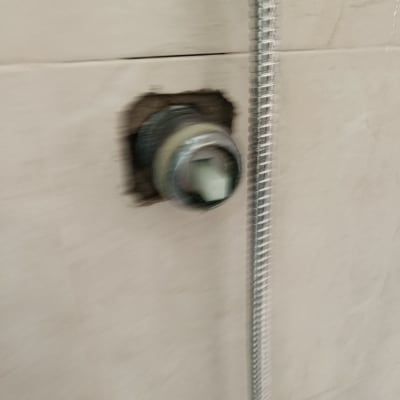 צינור מתכת מחובר לקיר עם חור