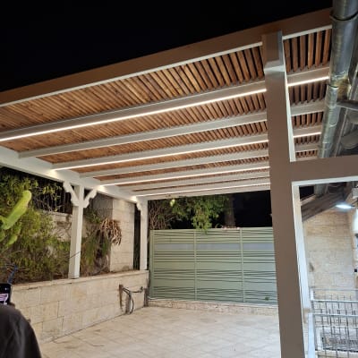 פרגולה מעץ עם תאורה בחצר בלילה