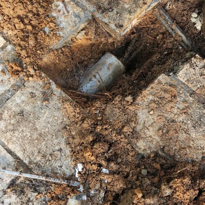 כלי עבודה חשמלי ליד חפירה בצינור באדמה