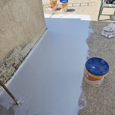 מריחת חומר איטום לבן על רצפה חיצונית