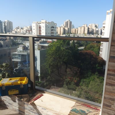 מעקה זכוכית במרפסת עם נוף עירוני