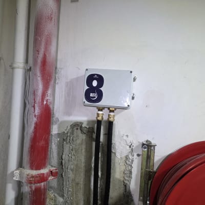 צינור אדום וארון חיבורים על קיר בטון