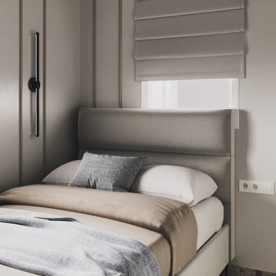 חדר שינה עם מיטה אפורה וכריות מעוצבות