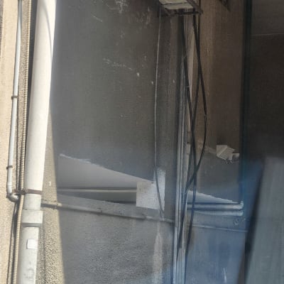 יחידת מזגן חיצונית מותקנת על קיר עם צינורות חשמל