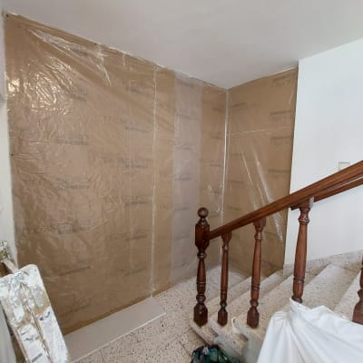 קיר גבס עם כיסוי פלסטיק שקוף ומדרגות עץ