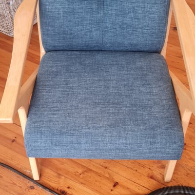 כיסא כחול עם צינור ניקוי על רצפת עץ