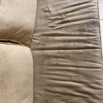 כרית ספה עם כתמים וקמטים על הבד