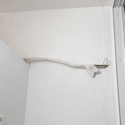 קיר צבוע בלבן עם מדף עץ מתחתיו