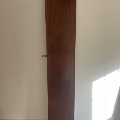 דלת עץ חומה עם צירים על קיר לבן