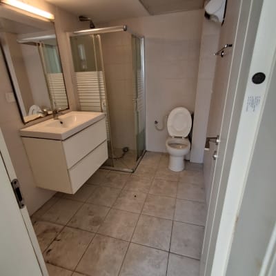 חדר אמבטיה עם מקלחת, כיור ואסלה