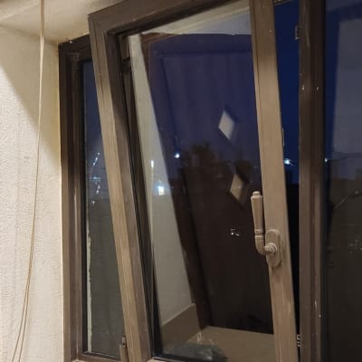 תריס גלילה חום מעל חלון פתוח בזווית