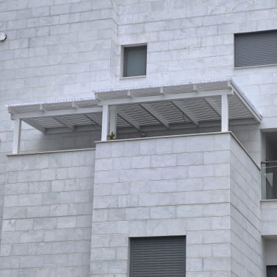 פרגולה מעץ לבן על מרפסת בניין