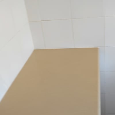 ארון מטבח עם ידית מתכת על רקע קיר אריחים