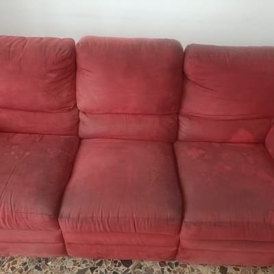 ספה אדומה עם כתמים על הרצפה