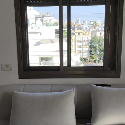 חלון אלומיניום עם נוף עירוני ברקע