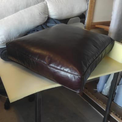 כרית עור חומה על שולחן עם ריפוד לבן