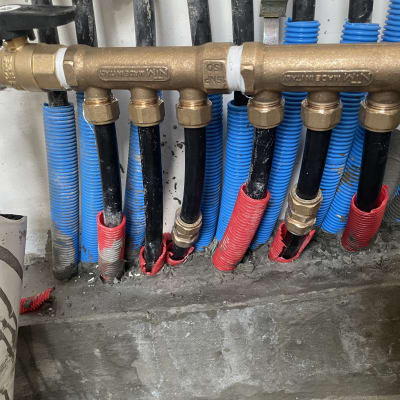 צינורות שחורים עם מחברים ממתכת, עטופים בכחול ואדום