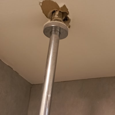 צינור מתכת יוצא מתקרה עם חור