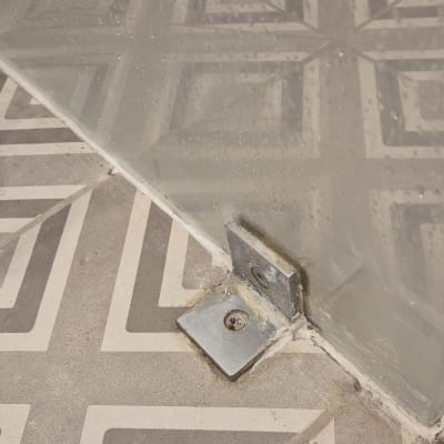 תושבת מתכת על רצפת אריחים עם זכוכית