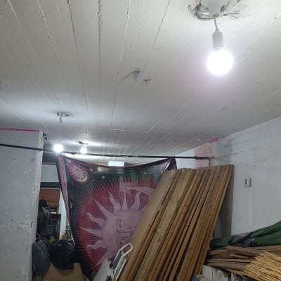 נורה דולקת בתקרה עם חוטי חשמל גלויים