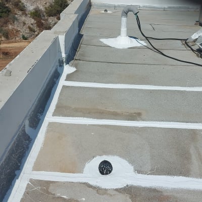 איטום גג עם חומר לבן סביב צינור וניקוז