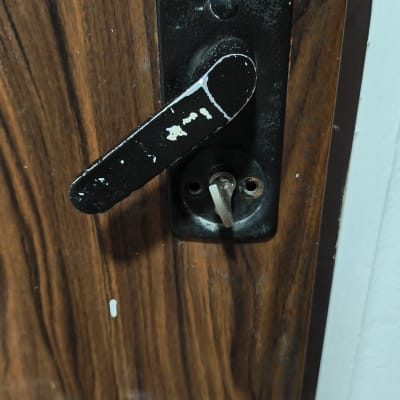 ידית דלת מתכתית על דלת עץ