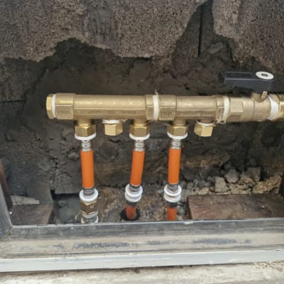 צינורות כתומים מחוברים לברזי פליז בקיר