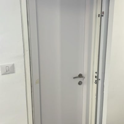 דלת לבנה עם ידית כסופה וקיר לבן