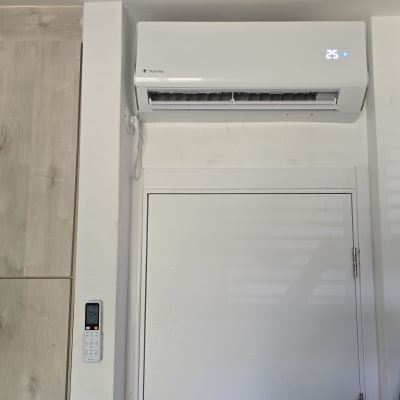 מזגן מותקן על קיר עם שלט רחוק תלוי