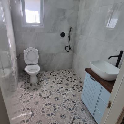 חדר אמבטיה משופץ עם אריחים מעוצבים, כיור ומקלחת