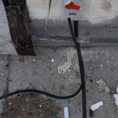 מתג חשמלי מותקן על קיר חיצוני עם חוטים