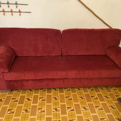 ספה אדומה על רצפת אריחים צהובה