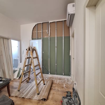 קיר גבס בבנייה עם סולם וכלי עבודה